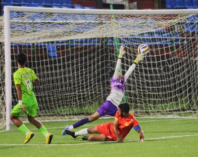 Mawlai's Loving Suting (left) watches as his shot beats the Mylliem goalkeeper for his hat-trick goal