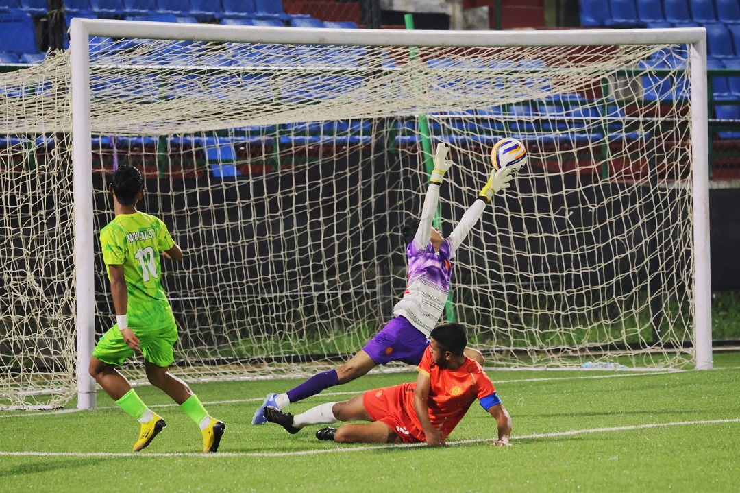 Mawlai's Loving Suting (left) watches as his shot beats the Mylliem goalkeeper for his hat-trick goal