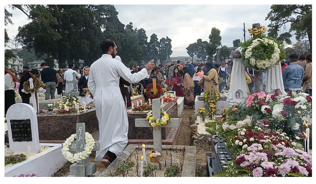 All Souls’ Day, a solemn occasion dedicated to praying for the departed, was observed with deep reverence across the Shillong Archdiocese on Sunday. The Mother Parish of Laitumkhrah, the central parish of the Archdiocese, witnessed particularly large gatherings as the faithful came together in prayer and remembrance. Hundreds of believers offered prayers, laid flowers, and lit candles at the cemetery, paying tribute to deceased family members, friends, and all the departed faithful. The faithful sought God’s mercy and eternal peace for their souls. A Holy Mass at the Grave Yard of Laitumkhrah Parish was presided over by Most Rev. Victor Lyngdoh, Archbishop of Shillong, who served as the main celebrant. In his homily, Archbishop Lyngdoh reflected on the spiritual meaning of All Souls’ Day and called upon the faithful to contemplate eternal life and the hope found in God. “Our prayer today is not only to remember those who have gone before us, but also to renew our hope in God, who grants us eternal life,” Archbishop Lyngdoh said. He urged families and communities to continue practicing acts of love, prayer, and remembrance as expressions of unity with the souls of the departed. All Souls’ Day remains an important tradition in the Catholic Church, emphasizing prayers for the souls in purgatory so that they may attain eternal rest in God’s presence. Following the Mass, Archbishop Lyngdoh led a special prayer service and blessed the graves, as the congregation joined in solemn devotion to honor and remember their loved ones who have passed on.